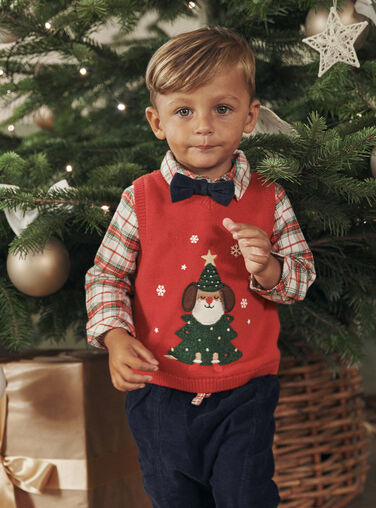 Bébé Dans Un Bonnet De Noël Dans Un Pull Et Des Chaussettes En Laine Sur Un  Traîneau Dans Un Intérieur Du Nouvel An